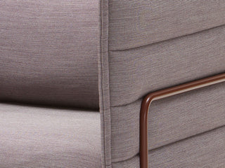 Detail van de grijsmauve stof en het koperkleurige buisframe van de Vitra Alcove
