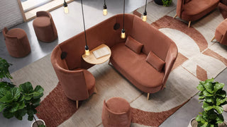 Sfeerbeeld van een lounge met terracotta Mobitec Bolero bank, fauteuils en poefs van bovenaf
