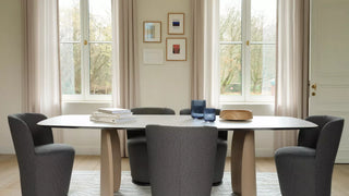 Sfeerbeeld van antraciet Mobitec Bolero fauteuils rond een ovale witte eettafel