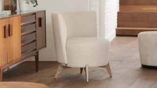 Sfeerbeeld van een crème Mobitec Bolero fauteuil met poef naast een houten dressoir