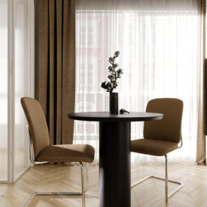 Lifestyle image of brown Bejot Hens cantilever chairs at a round black bistro table