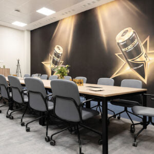 Lifestyle image of black Bejot Hens chairs around a long meeting table with photo wallpaper