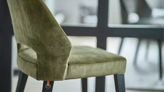 Detail van een olijfgroene velours Mobitec Lena stoel met open rug