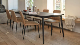 Sfeerbeeld van cognac Mobitec Rob stoelen met zwarte poten aan een houten tafel