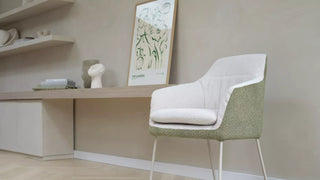 Lifestyle image of a Mobitec Saga chair with ecru seat and green back at a desk