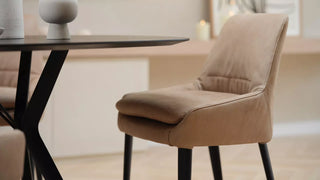 Lifestyle image of a camel Mobitec Saga chair at a round black table