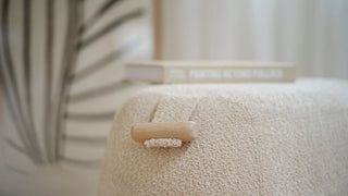 Detail van een ecru bouclé Mobitec Thalia poef met houten handgreep