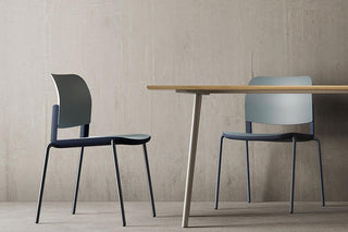 Lifestyle image of black and grey Bejot Volo chairs at a wooden table
