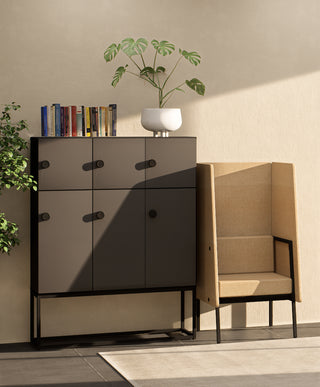 Lifestyle image of a black Buronomic Locker Eko nine-compartment locker next to a beige armchair