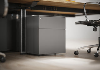 Photo d'ambiance de caissons métal Buronomic Paisible anthracite sous un bureau en bois