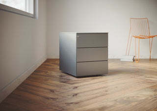 Photo d'ambiance d'un caisson métal Buronomic Paisible à trois tiroirs en aluminium sur parquet