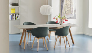 Sfeerbeeld van een eiken HAY CPH 30 tafel met groene stoelen op een blauwe vloer