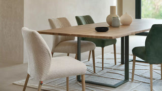 Sfeerbeeld van crème en groene Mobitec Enora stoelen aan een houten eettafel