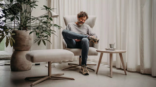 Lifestyle image of a man in a light Mobitec Enora lounge chair with footstool