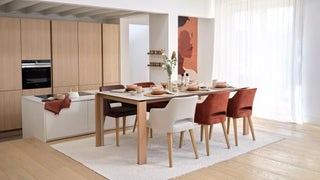 Sfeerbeeld van witte en roestrode Mobitec Lena stoelen aan een houten tafel in een open keuken